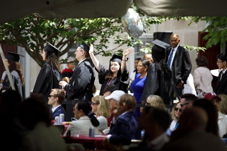 A graduate waves during a ceremony for the Class of 2026 at Dunster House.