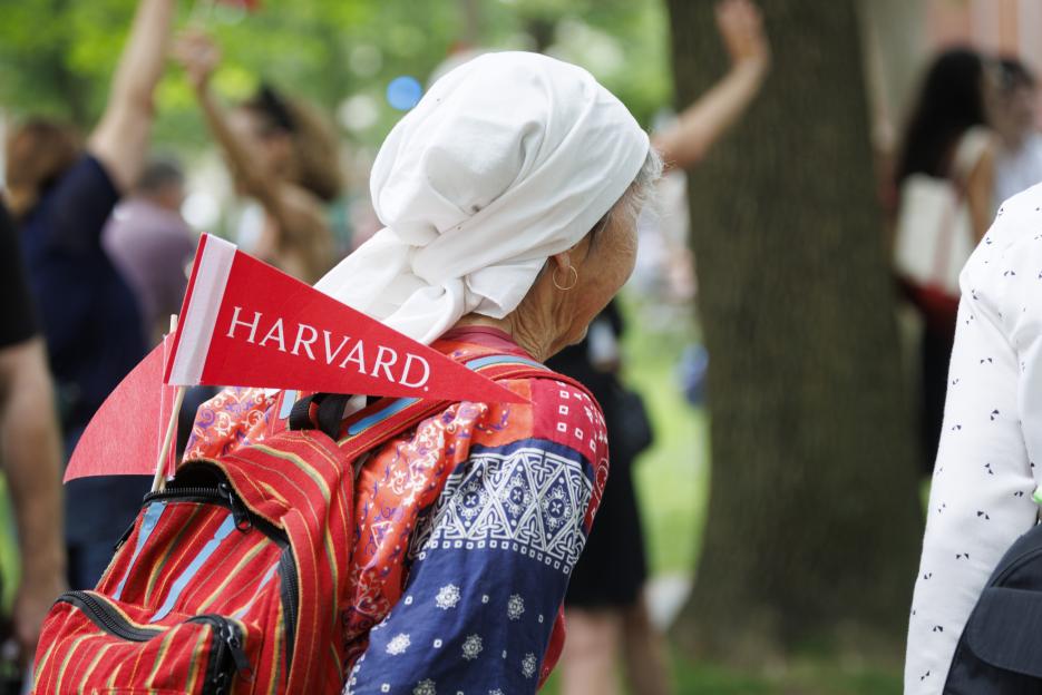 A Harvard pennant sticks out of an attendee’s backpack during Alumni Day, 2025.