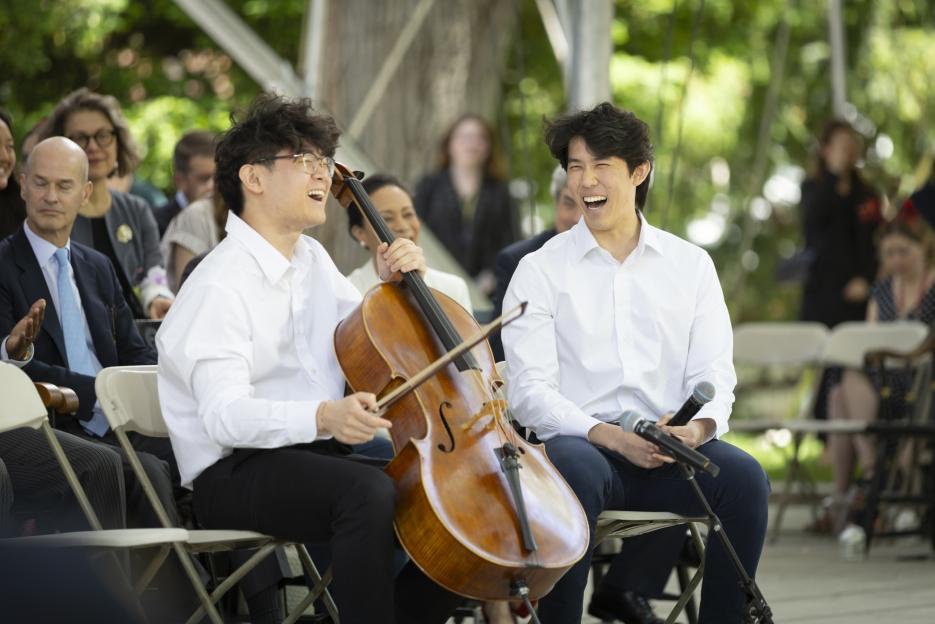 Eugene Ye COL ’25 (left) and Eliot Min AB ’23 share a laugh before performing “Julie-O.” on Harvard Alumni Day, 2024.
