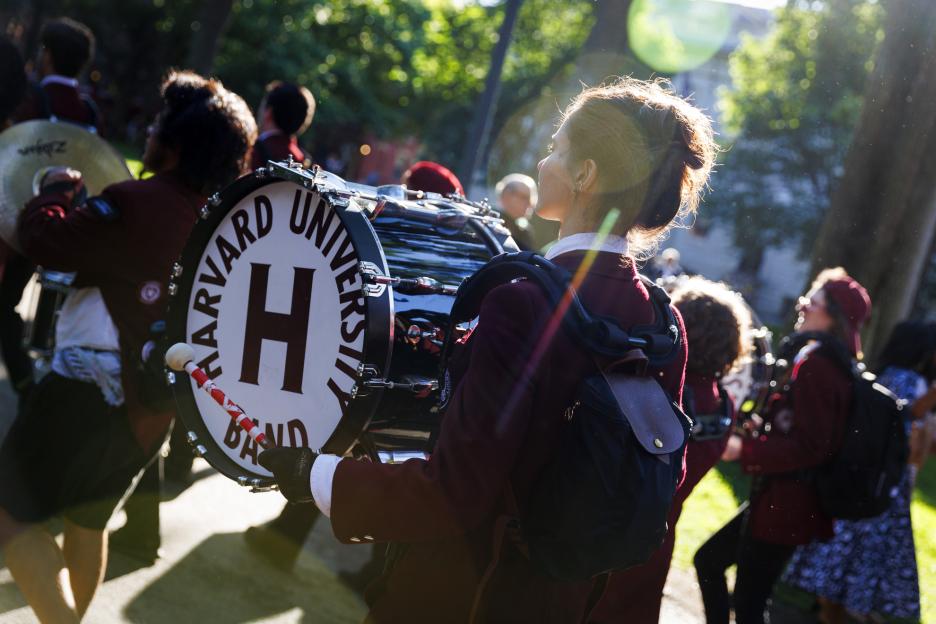 The drummer from the Harvard University Band processes past.